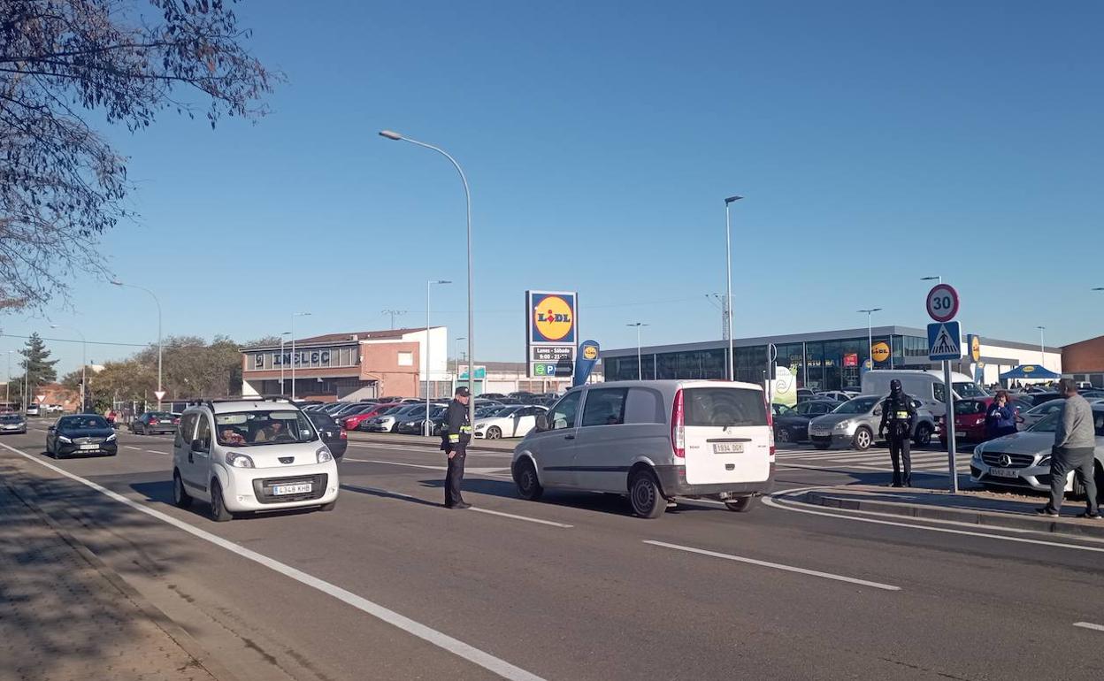 Dos agentes regulando el tráfico, a primera hora, en la entrada al nuevo supermercado. 