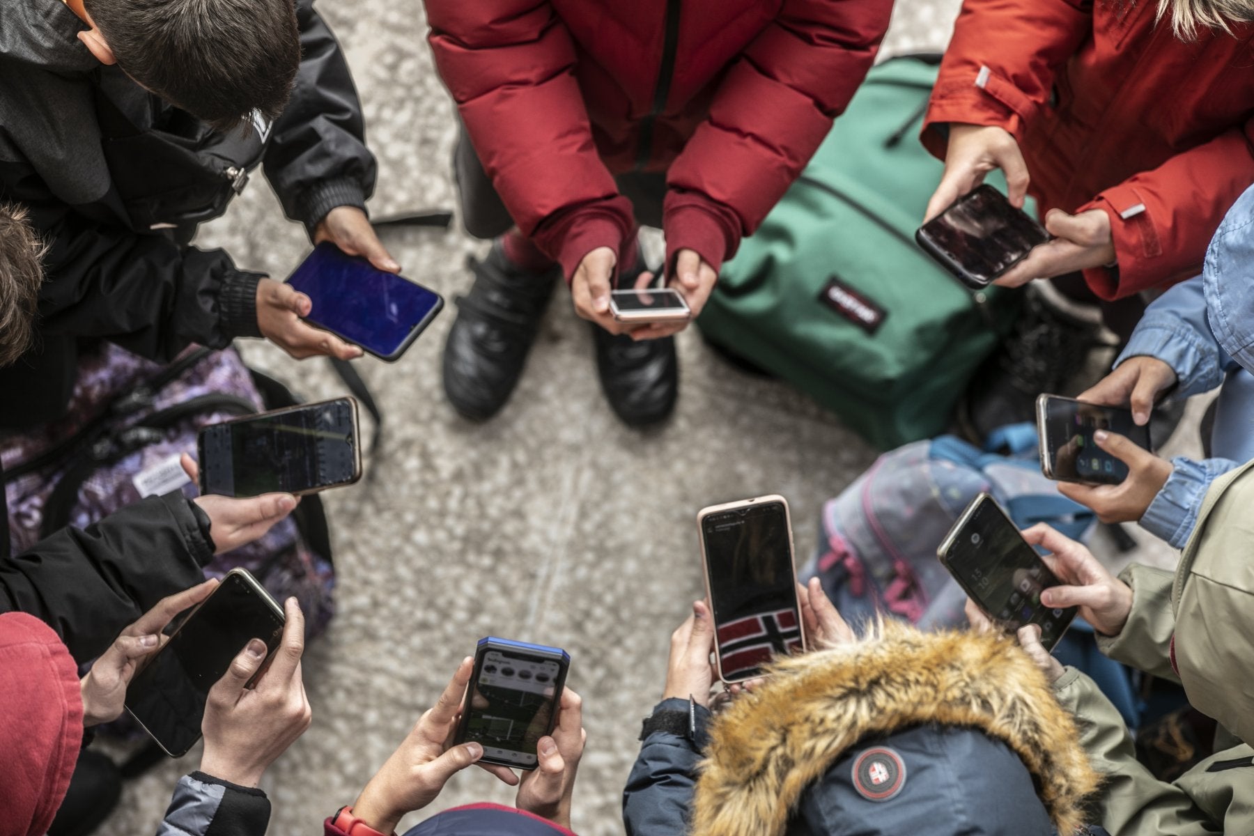 Varios estudiantes aprovechan la salida del colegio para hacer uso de sus dispositivos móviles. 