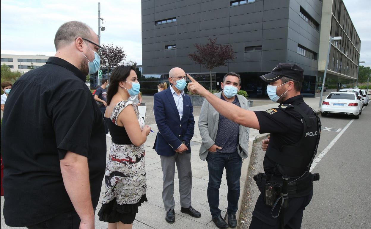 Representantes de las consejerías de Salud y Hacienda y un policía nacional en el desahucio del parking en julio de 2020. 