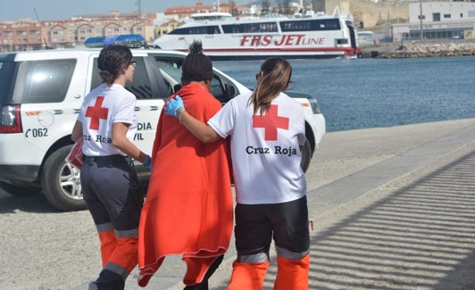 Voluntarios de Cruz Roja acompañan a una persona migrante. 