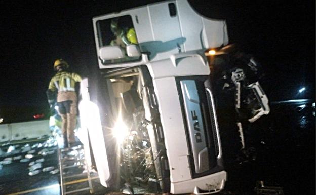 Imagen principal - Los Bomberos se han empleado a fondo en la intervención del accidente del camión.