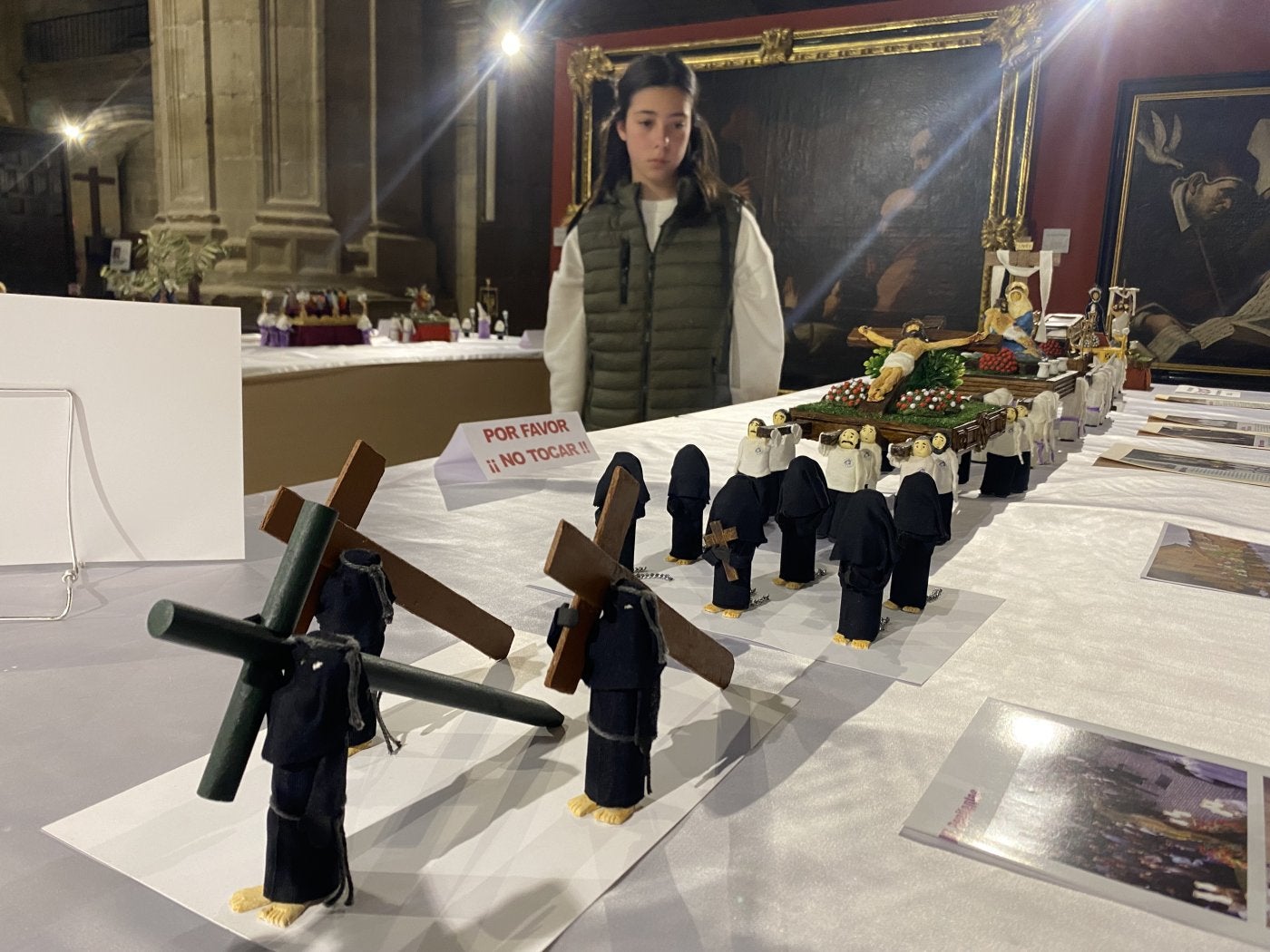 Una niña observa la procesión del Cristo Yacente. A la derecha, arriba, la Dolorosa con el nuevo palio y, abajo, visitantes en otro punto de la exposición.