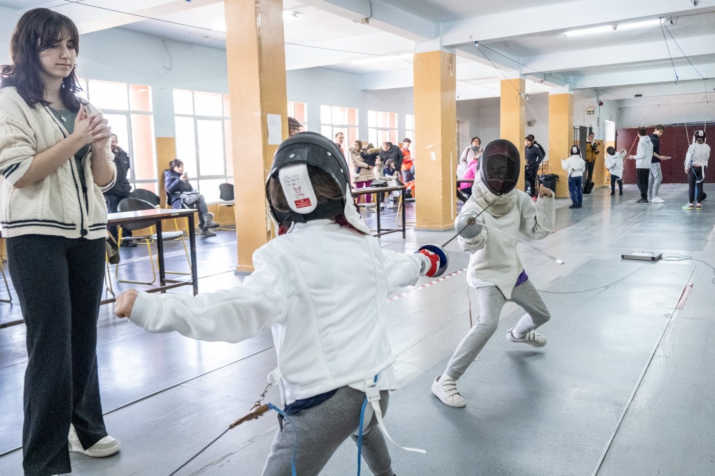 Una juez observa a los dos jóvenes tiradores.