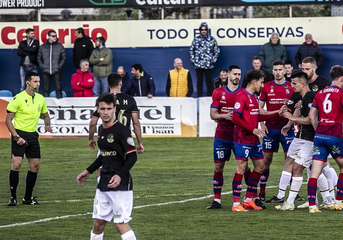 Un momento del partido, con aficionados al fondo.