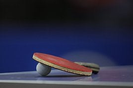 Una pala y una pelota de tenis de mesa.