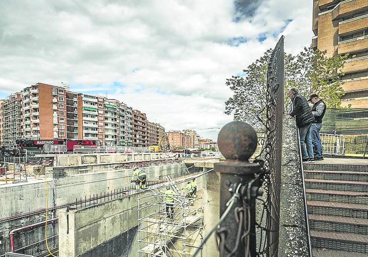 Vecinos mirando las obras con la grúa ya plegada al fondo.