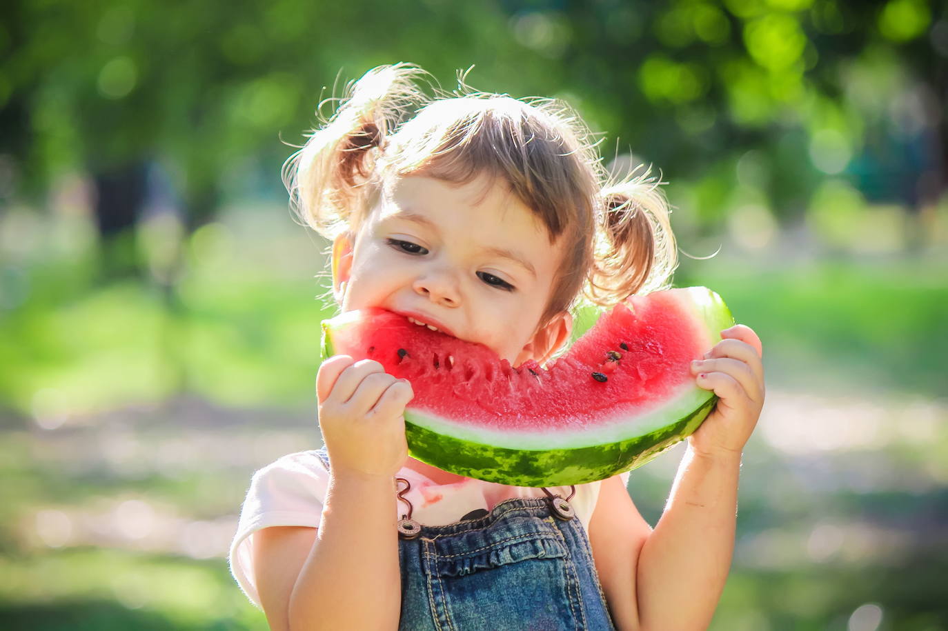 Una niña comiendo sandía.