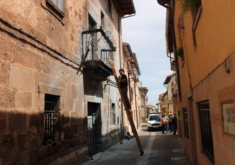 Imagen principal - Arriba, un técnico arregla los cables de la luz que se llevó por delante el camión. Debajo, Carlos Lerena, el joven que impidió que el fuego se extendiese por las casas. A la derecha, así ha quedado el balcón tras la colisión y el fuego. 