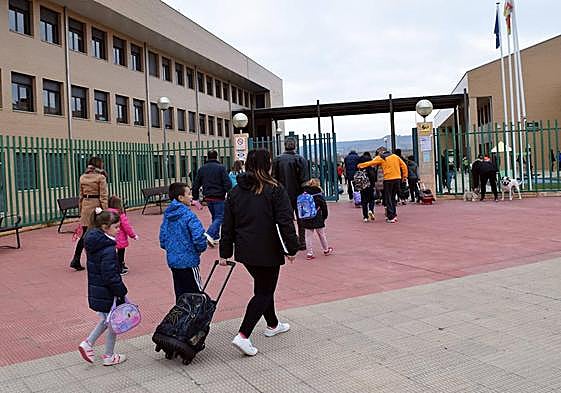 Una madre lleva a sus hijos al colegio.