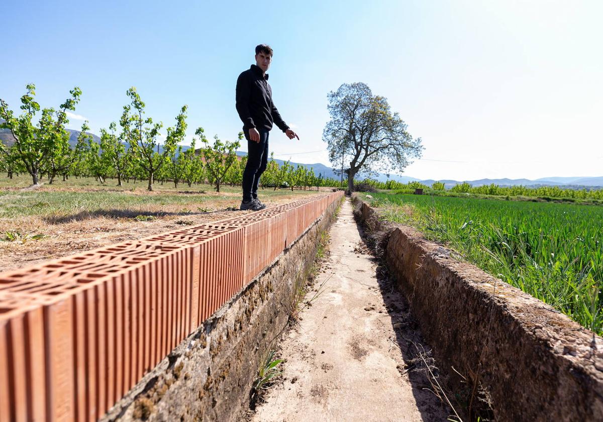 Víctor Justa señala una acequia sin agua en Albelda de Iregua.