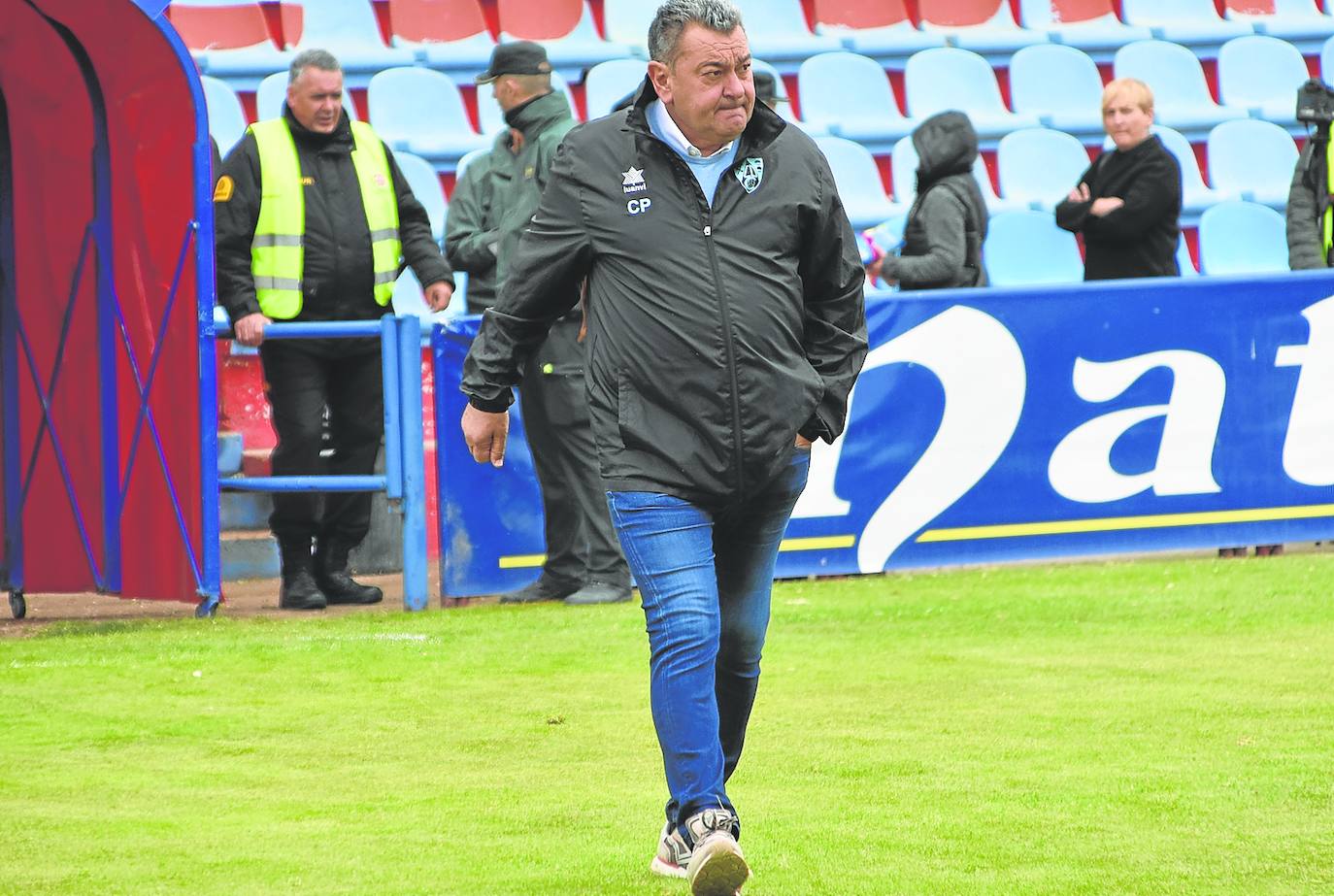 Carlos Pouso camina por el césped de La Planilla hacia su banquillo