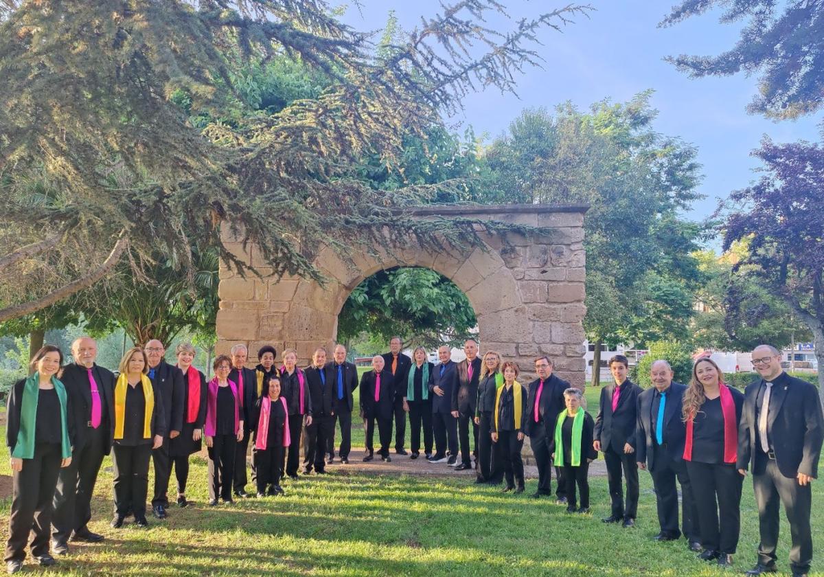 Las voces que forman actualmente el grupo de la Coral Najerense posan frente al arco de piedra que se encuentra en la ribera del Najerilla.