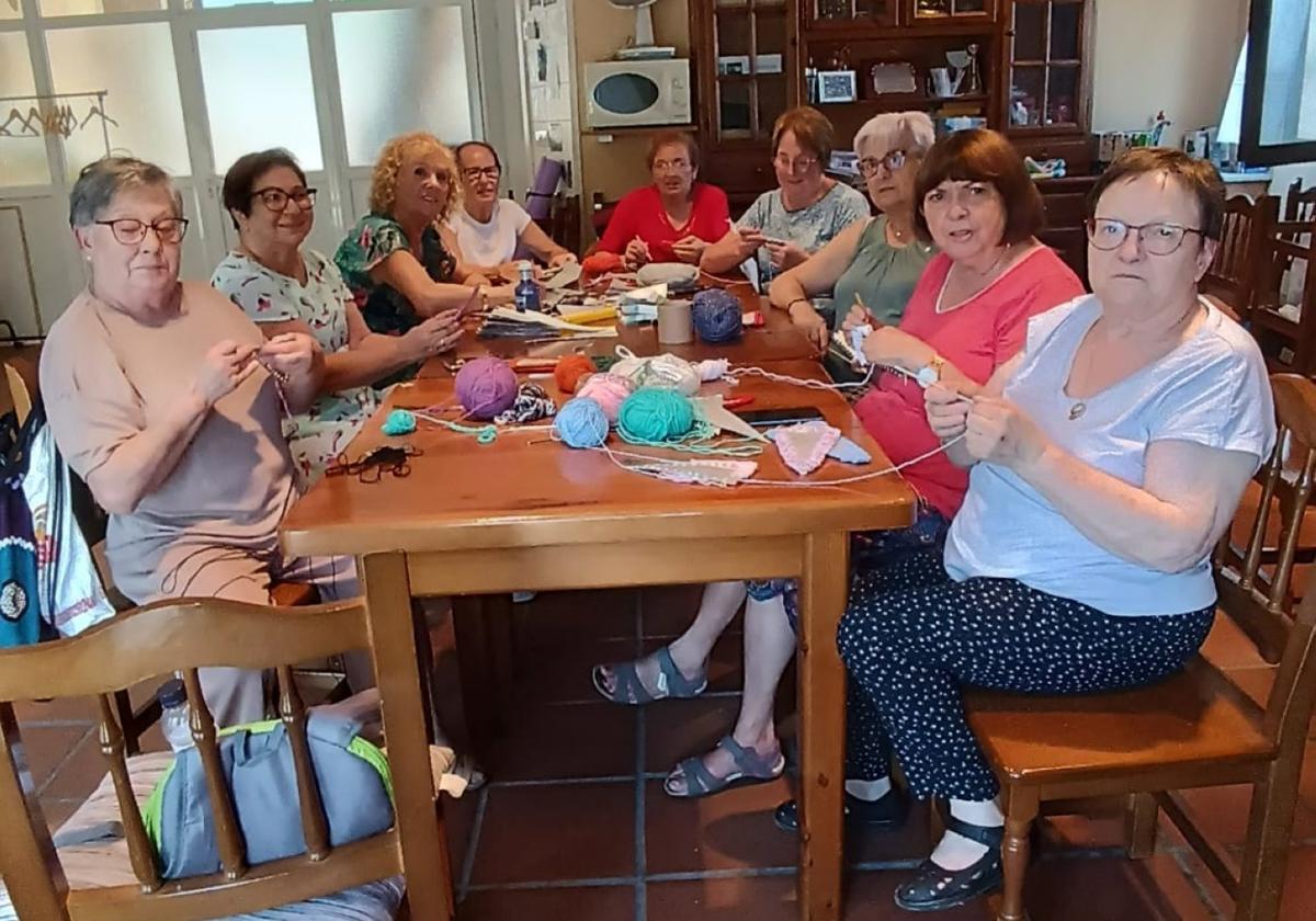 Las mujeres de San Millán trabajando en la confección de los banderines que adornarán el pueblo durante las fiestas de la Traslación.