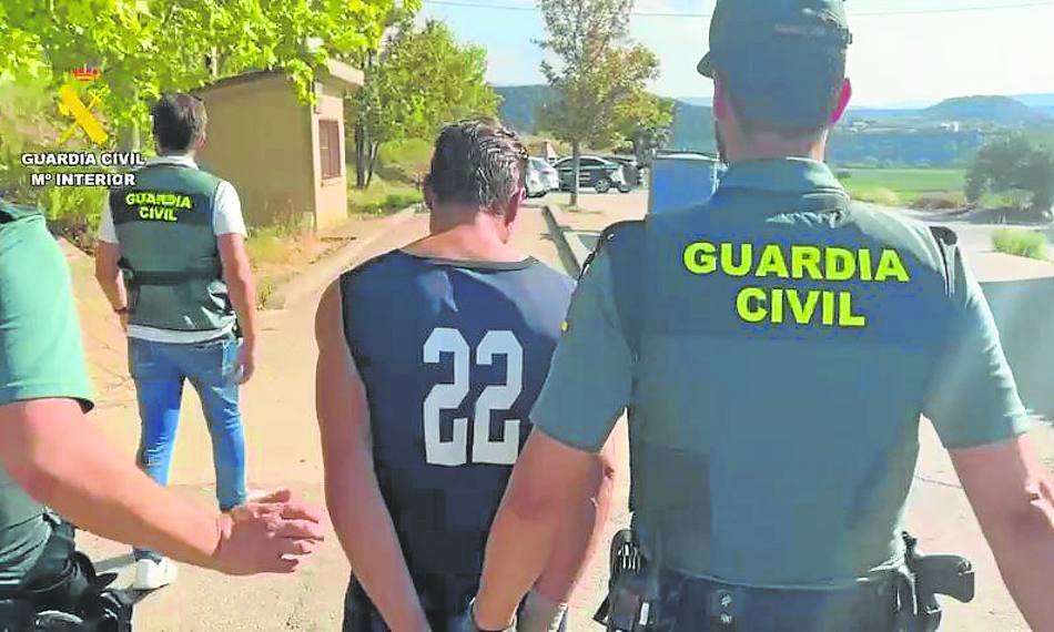 La Guardia Civil conduce esposado a uno de los dos presuntos asesinos.