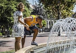 Un hombre se refresca en la fuente del Espolón de Logroño.