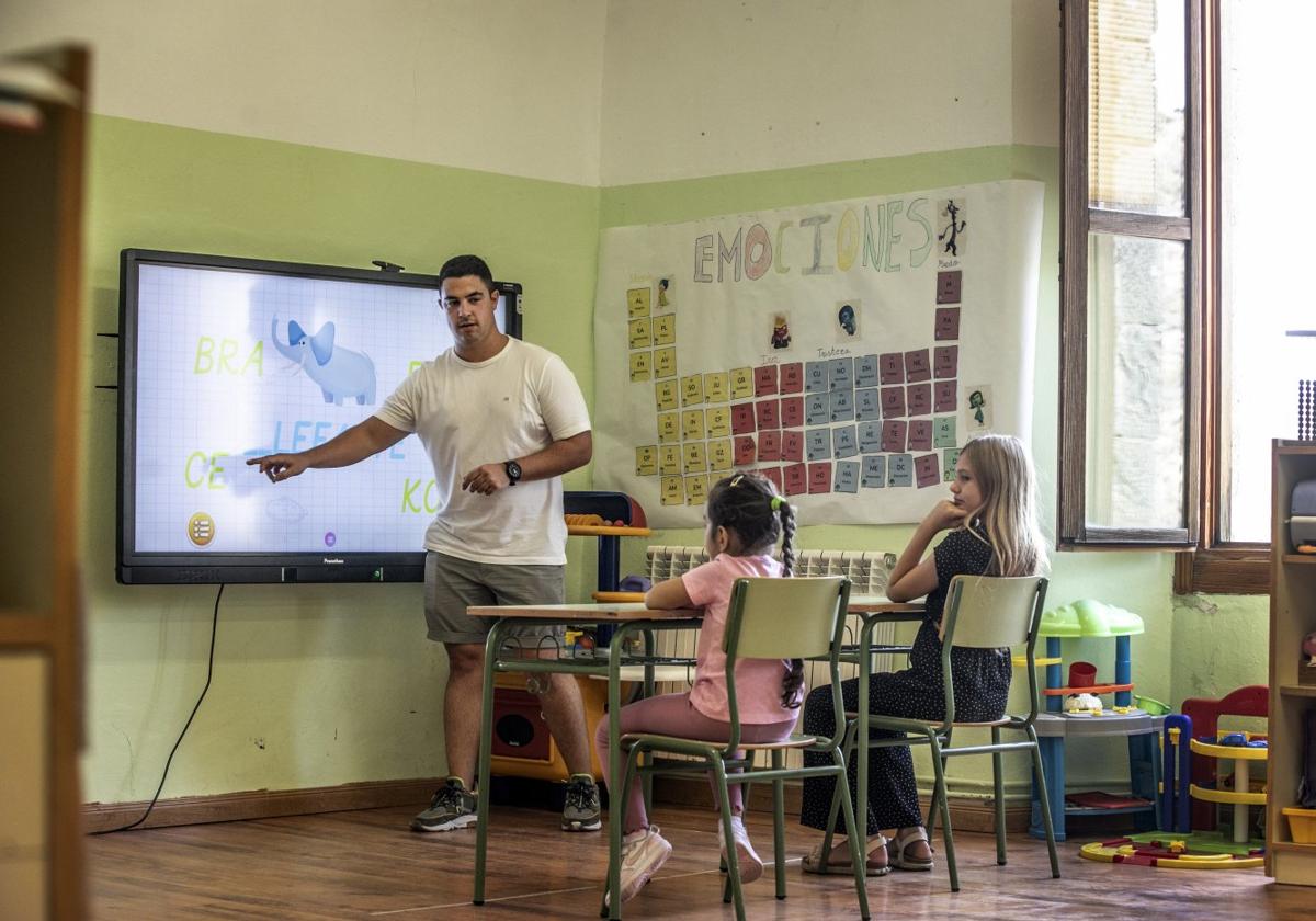 El maestro Óscar Virto imparte clase a Carla y Carmen, las únicas dos alumnas del colegio de San Román de Cameros, durante la jornada de ayer.