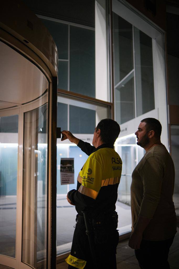 Un trabajador le enseña a un hombre la puerta.