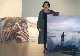 La artista Liza Ambrossio posa junto a dos de sus fotografías, en la Sala Amós Salvador de Logroño.