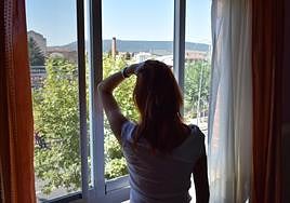 Begoña García mira por la ventana de su casa en Navarrete, que abandona definitivamente por el continuo acoso de un hombre a su familia.