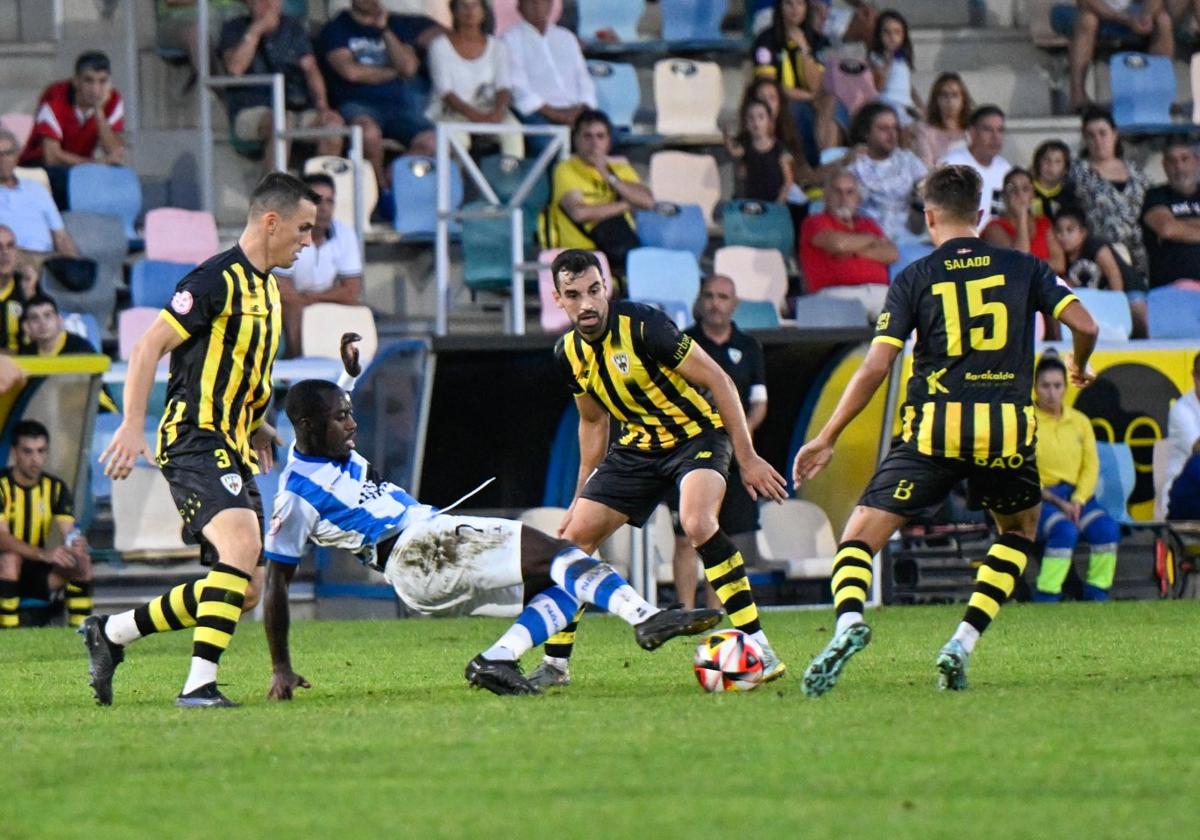 Aitor Lorá cae al suelo intentando hacerse con el esférico rodeado de jugadores del Barakaldo.