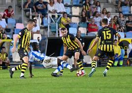 Aitor Lorá cae al suelo intentando hacerse con el esférico rodeado de jugadores del Barakaldo.