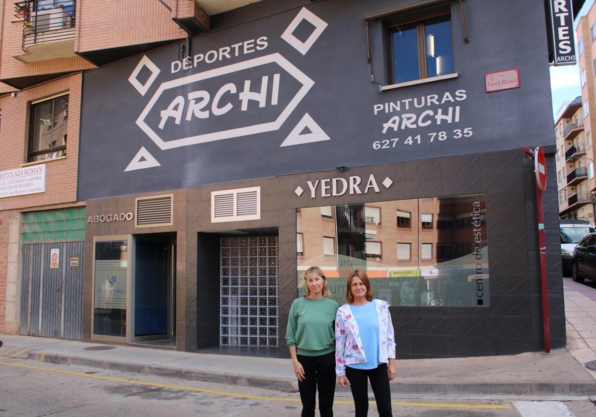 Ana y Cheles posan frente a la fachada de Deportes Archi, que bajará la persiana a finales de diciembre.