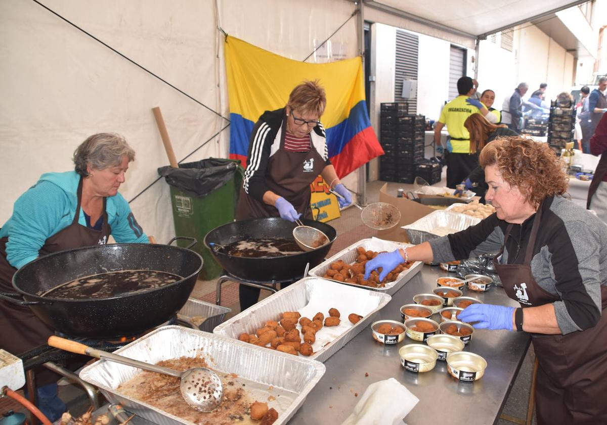 Imagen principal - Arriba las croquetas se sirvieron en cuencos con tres unidades. Abajo a la izquierda varios guisos de champiñón con caza, para elegir. Abajo a la derecha gran ambiente en la cocina popular de Autol. 