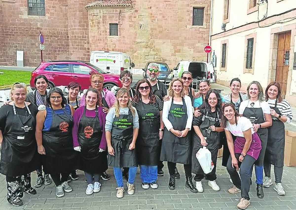 Imagen secundaria 1 - A la izquierda miembros de las Ampas de los colegios colaboraron en el evento. A la derecha el asado se realizó con leña y sin agua, de forma tradicional.