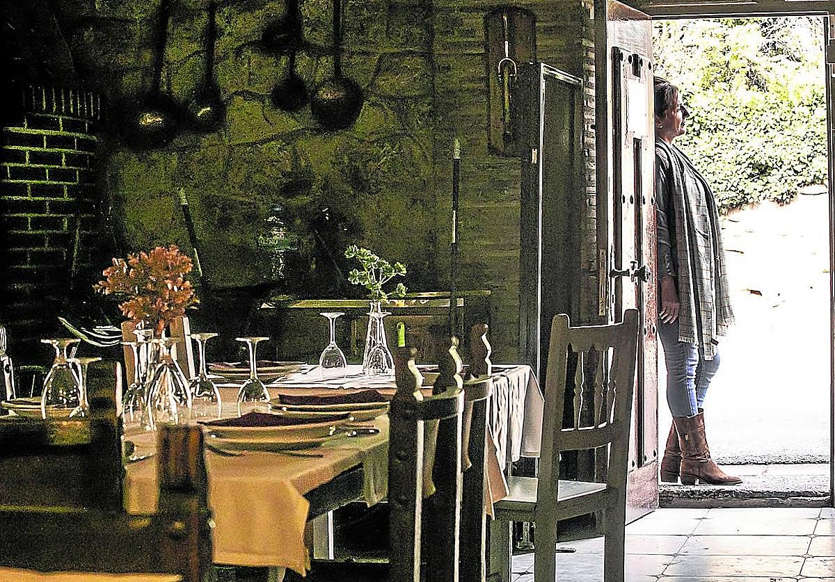 La hija del hostelero asesinado, en la puerta del restaurante, que permanece cerrado a la espera de poder despedir a su padre.