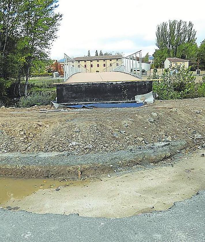 Imagen secundaria 2 - A la izquierda, una caseta y tablones amontonados junto a la pasarela.Sobre estas líneas, el final de la estructura que debería tener continuación.