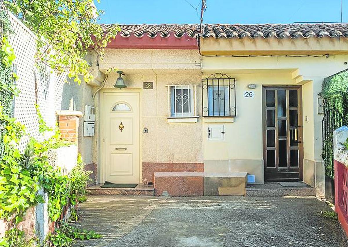 Imagen secundaria 1 - A la izquierda las puertas de las viviendas, este lunes, con nuevas cerraduras. A la derecha los servicios de limpieza frente al lugar de los hechos. 