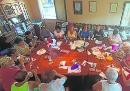 Las mujeres del Hogar del Jubilado de San Millán charlan sobre la idea del libro de recetas mientras trabajaban en la confección de banderines.