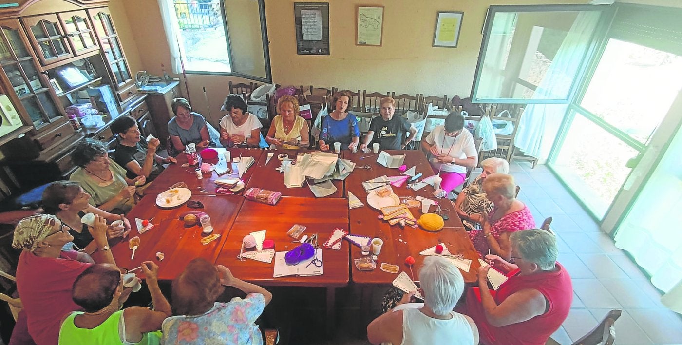 Las mujeres del Hogar del Jubilado de San Millán charlan sobre la idea del libro de recetas mientras trabajaban en la confección de banderines.
