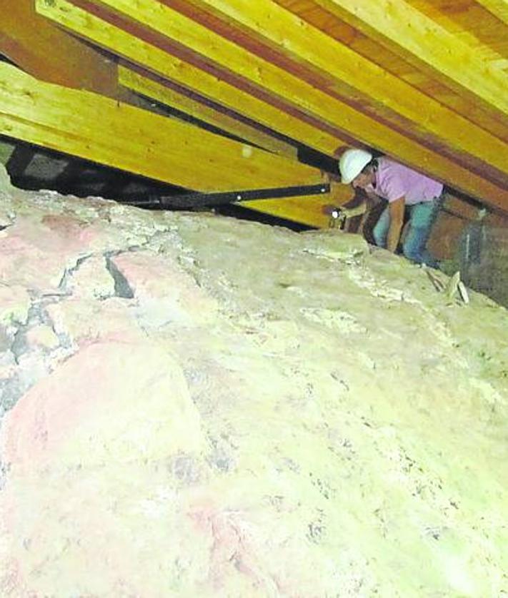 Imagen secundaria 2 - Arriba Roldán explica algunos de los aspectos de la obra durante la visita a la torre del campanario. Abajo a la izquierda cornisa románica del monasterio tras su restauración. Abajo a la derecha grieta en el interior de una de las bóvedas antes de la intervención. 