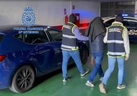 Dos agentes trasladan a uno de los catorce detenidos