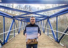 Javier Muro posa con la portada de su libro.