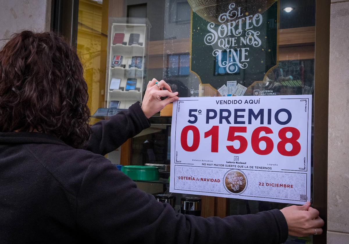 La responsable del estanco de Doce Ligero, con el cartel del premio.