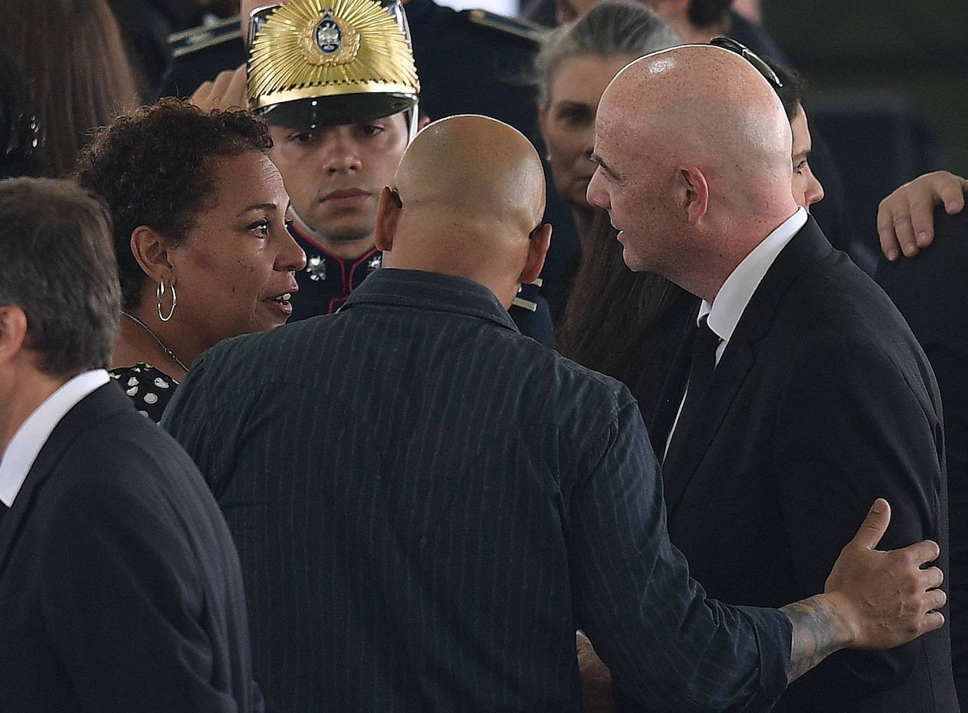 El presidente de la FIFA, Gianni Infantino (derecha), habla con los hijos de Pelé, Kelly Cristina (izquierda) y Edinho (centro), durante el velatorio del astro en el estadio del Santos.