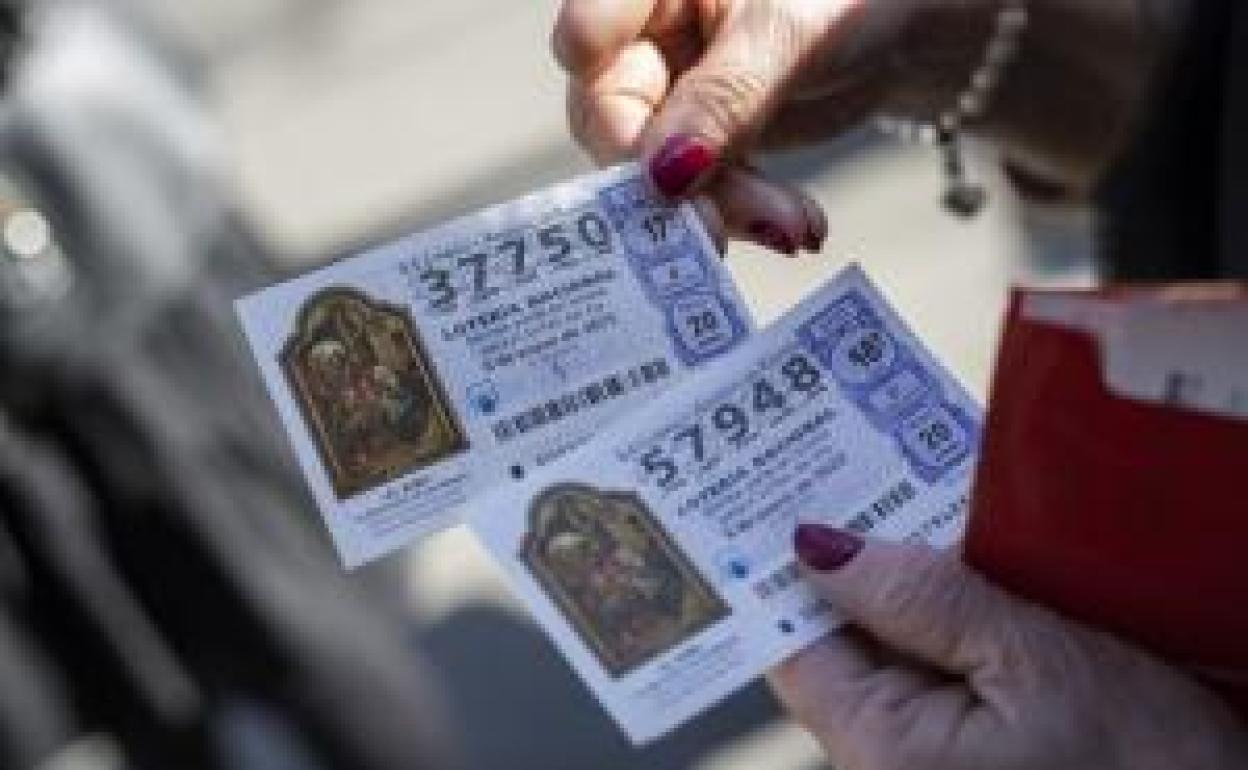 Una mujer sostiene dos décimos para el Sorteo Extraordinario del Niño, que se celebra este viernes a las 12. 