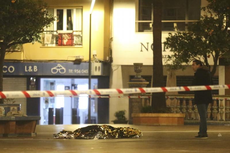 Una persona yace bajo una manta térmica la Plaza Alta de Algeciras tras el ataque.