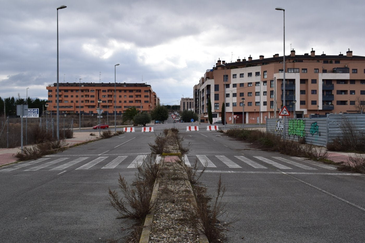 Vista de la parte construida y habitada del Sector T-1 del barrio Entre Ríos, con la calle Río Duero al fondo, desde la zona comercial abandonada. 