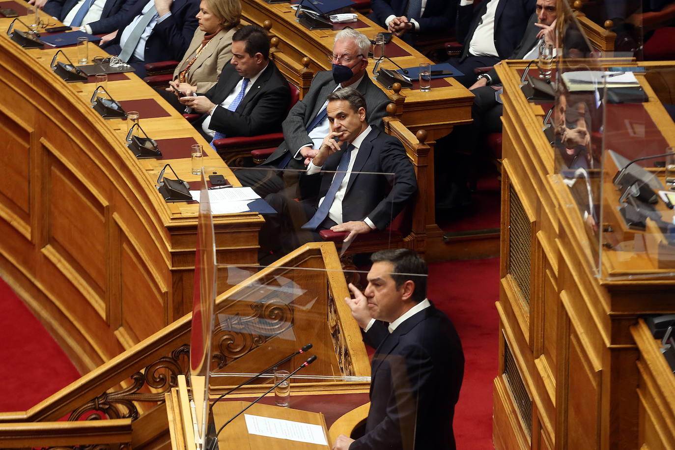 El primer ministro griego Mitsotakis escucha el discurso del líder opositor Alexis Tsipras en el Parlamento