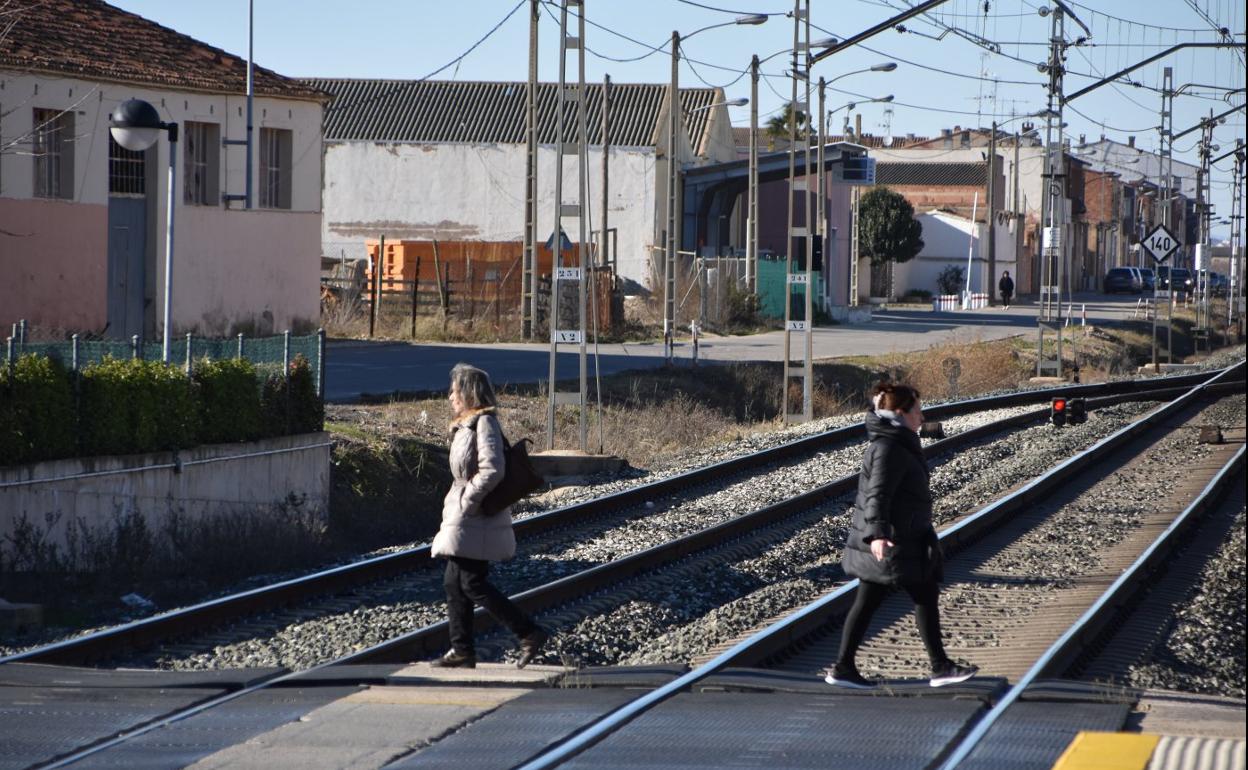 Dos mujeres cruzan la vía en el apeadero. 