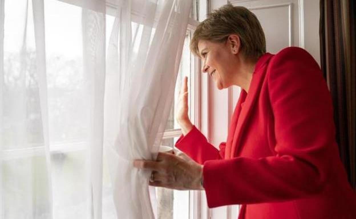 Nicola Sturgeon saluda a los cientos de seguidores que se concentraron frente al palacio de Bute House al conocer su renuncia