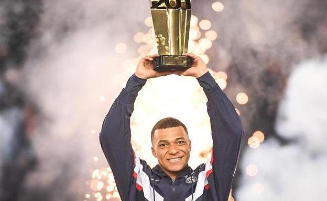 Kylian Mbappé levanta el trofeo conmemorativo por su récord goleador en el PSG.