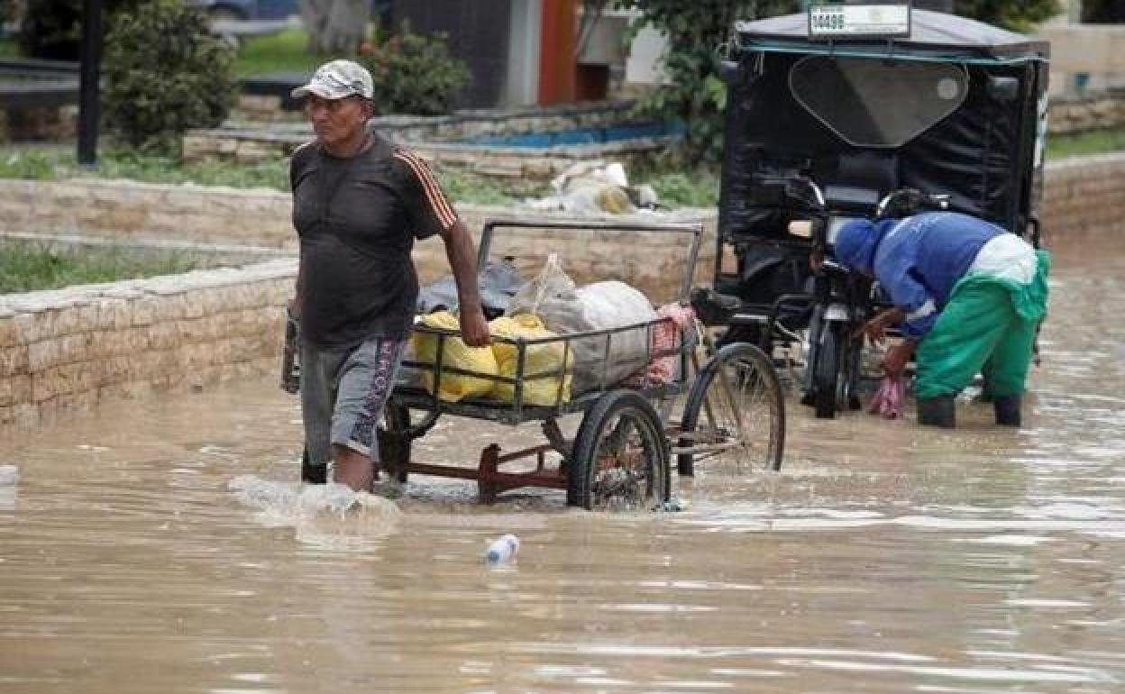 Un hombre camina por una calle inundada de la ciudad de Tumbes.