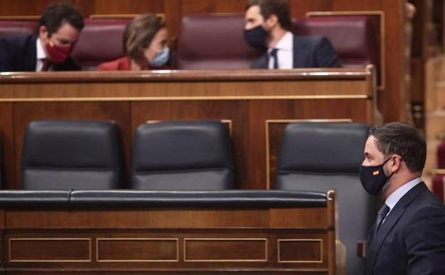 Santiago Abascal pasa junto al escaño de Pablo Casado tras su fallida moción de censura en 2020.