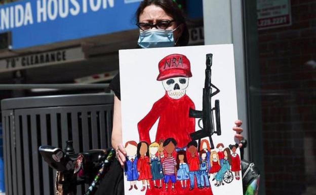 Una mujer sostiene un cartel contra las leyes de armas en Houston, Texas.