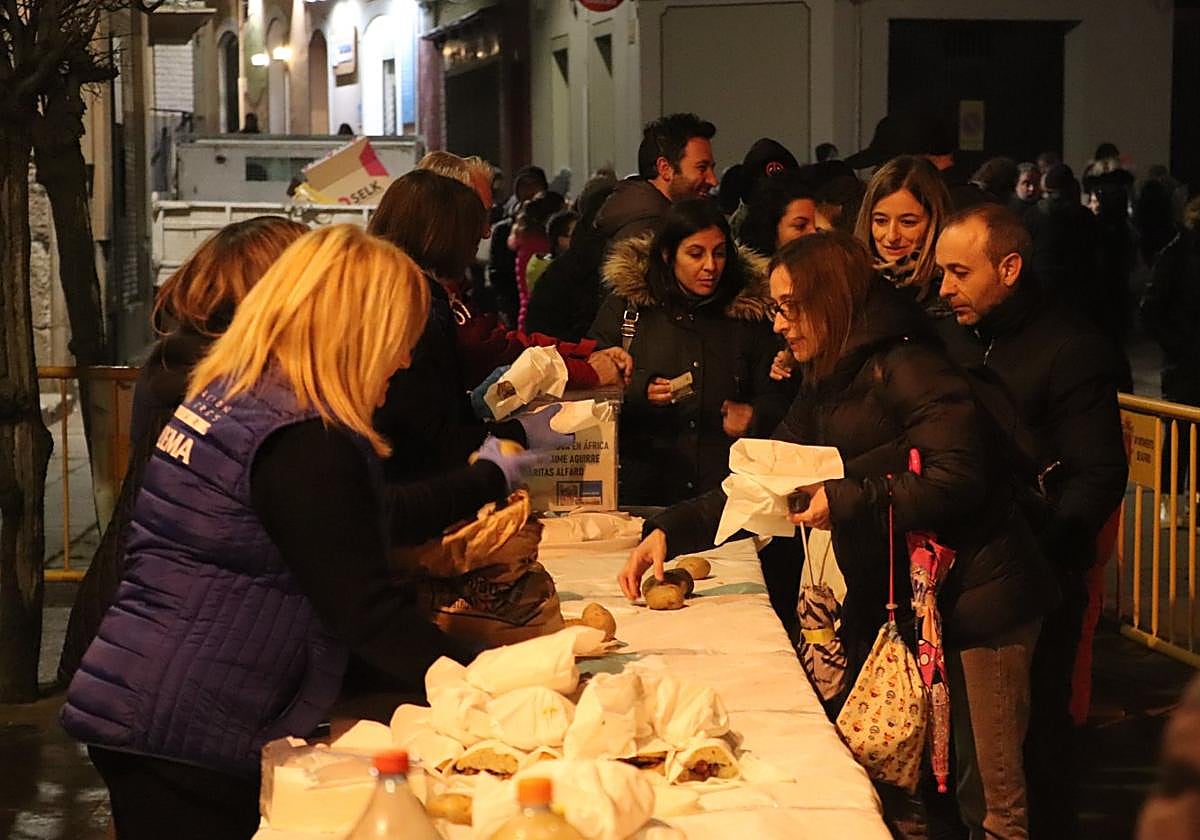 Pese a la nieve y el frío, cientos de personas se acercaron a la degustación solidaria de la hoguera municipal.