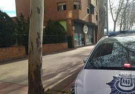 Un coche de Policía Local aparcado junto a la vivienda donde se ha producido el fuego.